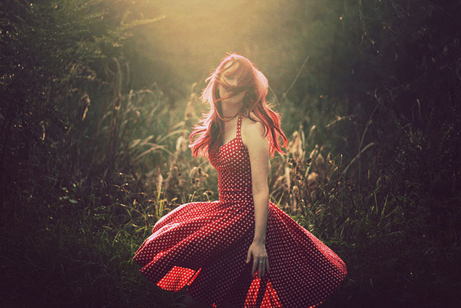 Piros pöttyös ruhás lány a réten.