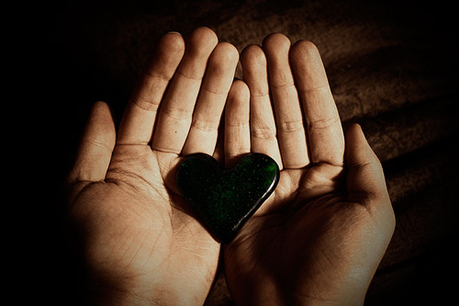 Egy szív kő egy emberi tenyérben.