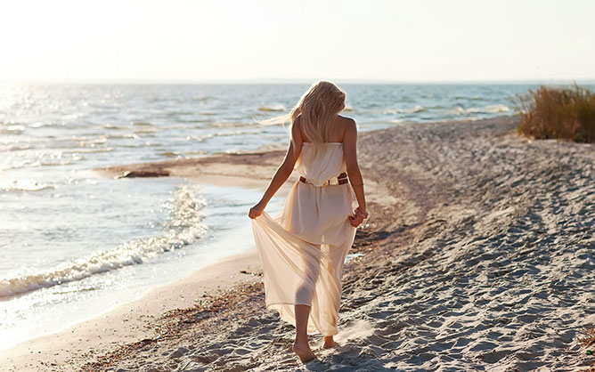 Sétáló nő a tengerparton.